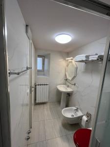 uma casa de banho branca com um lavatório e um WC em B&B Dante Alighieri em Florença