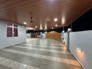 a large room with a tile floor and wooden ceiling at Shan Homestay in Sungai Petani