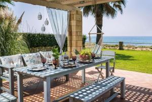 a table with glasses of wine on a patio at Astounding Seafront Kefalonia Villa - 3 Bedrooms - Villa Alegria - Private Pool and Amazing Sea Views - Minies in Kefallonia