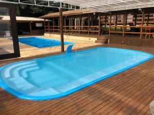 a large blue swimming pool on a wooden deck at RECANTO VERDES VALES in Palhoça