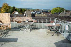 um pátio com mesas e cadeiras numa varanda em Friendly Home Doppel-Doppelappartement Union em Bornheim