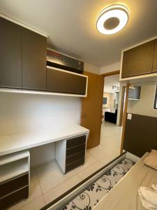 uma cozinha com uma secretária e armários e um quarto em Eco Summer Tambaú - Apartamento de Alto Padrão de 2 Quartos em João Pessoa