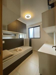 um pequeno quarto com uma cama e uma janela em Eco Summer Tambaú - Apartamento de Alto Padrão de 2 Quartos em João Pessoa