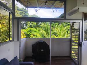 Zimmer mit einem großen Fenster und einem Rucksack in der Unterkunft Casa del sol in Bejuco