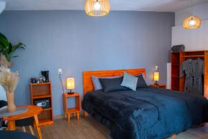 Dormitorio azul con cama y mesa en Piedra Negra Boutique Hotel en San Cristóbal de Las Casas