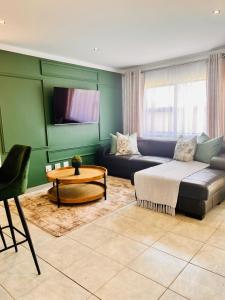 een woonkamer met een bank en een tafel bij Makarios in Pretoria