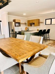 uma cozinha e sala de jantar com uma mesa de madeira e cadeiras em Makarios em Pretoria
