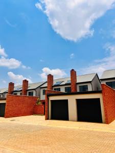 um edifício com duas portas de garagem e uma parede de tijolos em Makarios em Pretoria
