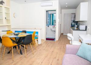 a kitchen and a living room with a table and chairs at Sunny House Apartment 44 Malta in Taʼ Xbiex