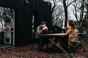 un hombre y una mujer sentados en una mesa bebiendo café en The Nest 81, en Heuvelland