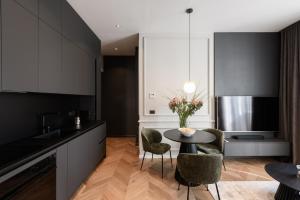 a kitchen with black cabinets and a table with chairs at Luxury Apartment con FREE PARK in Trieste