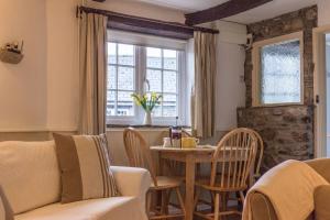 a living room with a table and chairs and a window at The Linhay in Hartland