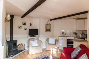 a kitchen and a living room with a fire place at The Linhay in Hartland