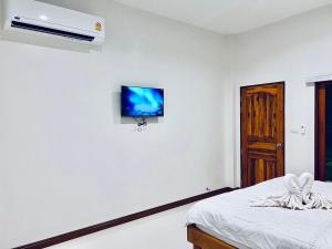 a bedroom with a bed and a tv on the wall at Sisters Home ที่พักใกล้สวนพฤกษศาสตร์ ระยองแหลมแม่พิมพ์ in Ban Ko Kok
