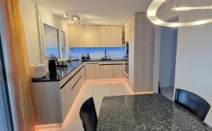 a kitchen with a table and chairs in a room at MENBERGS HARMONY HOMESTAY in Hildisrieden