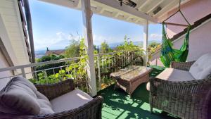 a balcony with wicker chairs and a hammock at MENBERGS HARMONY HOMESTAY in Hildisrieden