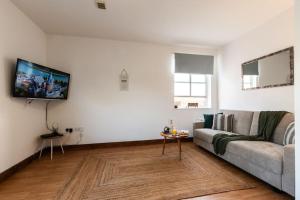 a living room with a couch and a tv at City Centre 1-bedroom apartment - Close to Solent-Hospital-Free Parking in Southampton