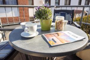 einen Tisch mit einem Buch, Tassen und einer Zeitschrift in der Unterkunft Ferienwohnung Margaretha, App 04 in Ostseebad Sellin