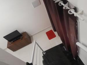 Eine Treppe mit einem roten Hocker und einem roten Handtuch in der Unterkunft CASA NA PRAIA GRANDE pé na areia in Praia Grande