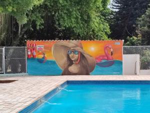 une peinture d'une femme à côté d'une piscine dans l'établissement Hotel Monalisa, à Foz do Iguaçu