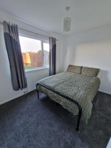 a bedroom with a bed and a window at Sunset Cottage in Stockton-on-Tees