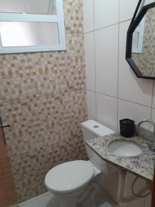ein Badezimmer mit Toilette und Waschbecken in der Unterkunft CASA NA PRAIA GRANDE pé na areia in Praia Grande + 24 Fotos
