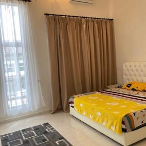 1 dormitorio con 1 cama y una ventana con cortinas en Camellia Homestay Semenyih, en Semenyih