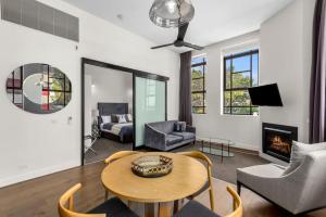 uma sala de estar com uma mesa e um sofá em Manhattan on Moorabool - Heritage Listed Geelong CBD em Geelong