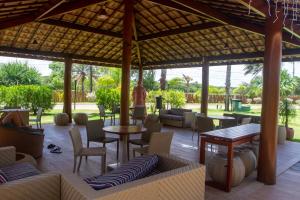 a patio at a resort with tables and chairs at Itacimirim - Quinta das Lagoas Reserva in Camaçari
