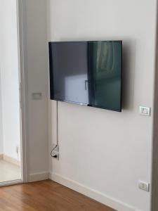 einen Flachbild-TV, der an einer weißen Wand hängt in der Unterkunft Labanca's Luxury center in Matera