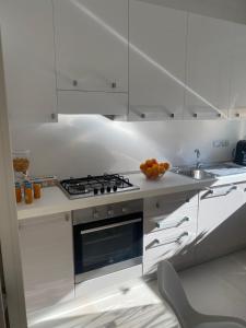 una cucina bianca con piano cottura e lavandino di Labanca's Luxury center a Matera