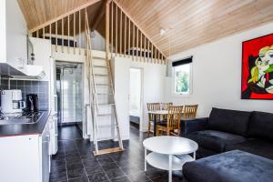 a living room with a loft bed and a kitchen at Kristinehamn Herrgårdscamping & Stugor in Kristinehamn