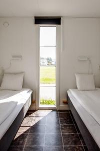 2 Betten in einem Zimmer mit Fenster in der Unterkunft Kristinehamn Herrgårdscamping & Stugor in Kristinehamn