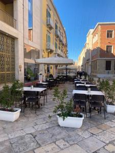 an outdoor patio with tables and chairs and umbrellas at Labanca's Luxury center in Matera