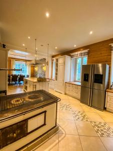 a large kitchen with a stainless steel refrigerator at Luxusvilla Österreich in Scheibbs