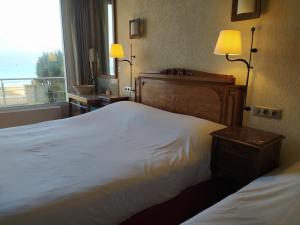 um quarto de hotel com uma cama grande e uma janela em Gites "Pieds dans L'Eau" ou "Plage" en FRONT DE MER à Asnelles , 3km d'Arromanches, 10km de Bayeux em Asnelles