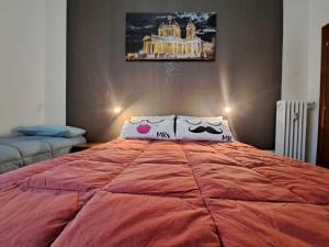 a bedroom with a large orange bed with two pillows at Family Dreams in Turin