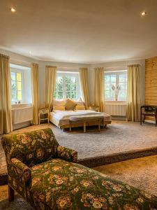 a bedroom with a bed and a couch and windows at Luxusvilla Österreich in Scheibbs