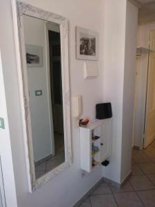 ein Spiegel hängt an einer Wand neben einem Bad in der Unterkunft Frida apartments in Sanremo