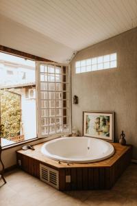 uma grande banheira num quarto com uma janela em Pousada Paty´s Garden em Florianópolis
