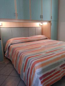 Un dormitorio con una cama con una manta a rayas. en Frida apartments, en San Remo
