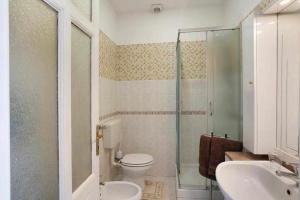 y baño con ducha, aseo y lavamanos. en Frida apartments en Sanremo