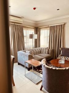 uma sala de estar com um sofá e uma mesa em Hotel Destiny em Ongwediva