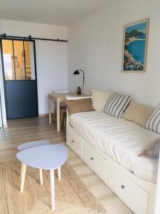 a living room with a white couch and a table at Studio Saint Cyr sur mer,Vue mer in Saint-Cyr-sur-Mer