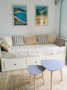 a living room with a couch with a table and a stool at Studio Saint Cyr sur mer,Vue mer in Saint-Cyr-sur-Mer