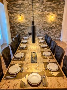 a long table with chairs and plates and a chandelier at Luxusvilla Österreich in Scheibbs