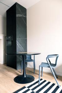 een zwarte tafel en een stoel in een kamer bij ComeCasa Fashion apartment Mantova in Milaan