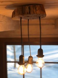 lampadario a braccio con luci appese a un soffitto di Liepų pirtis a Miežoniai