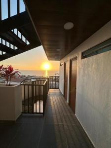 einen Balkon mit Blick auf den Strand bei Sonnenuntergang in der Unterkunft Monyxbnb Hotel in Puerto Vallarta
