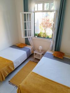 フンシャルにあるHome & Flower - Private bedrooms Funchalの窓付きの部屋 ベッド2台